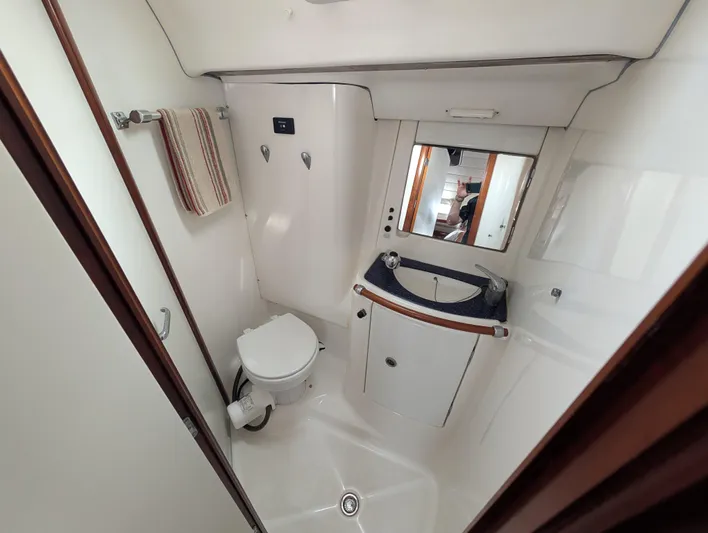 Seastar Yacht Photos Pics Bathroom interior of 2003 Beneteau Oceanis 473 yacht, featuring toilet, sink, and mirror.