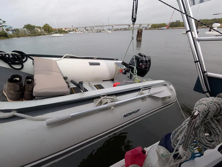 Seastar Yacht Photos Pics Inflatable dinghy moored beside a 2003 Beneteau Oceanis 473 sailboat on a calm river.