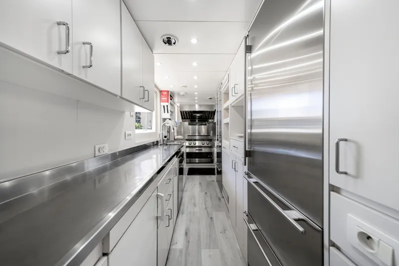 The Pearl Yacht Photos Pics Modern yacht kitchen with stainless steel appliances, sleek cabinetry, and bright lighting. Intermarine 118, 1998.