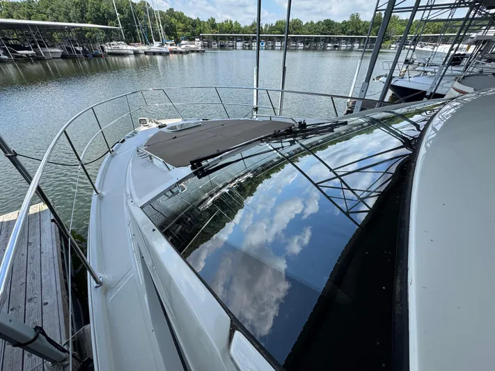 Finale Yacht Photos Pics 2017 Sea Ray Sundancer 400 docked at marina, reflecting blue sky and clouds.