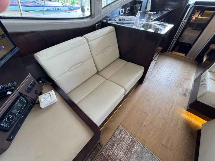 Finale Yacht Photos Pics 2017 Sea Ray Sundancer 400 interior with beige seating and wooden flooring.