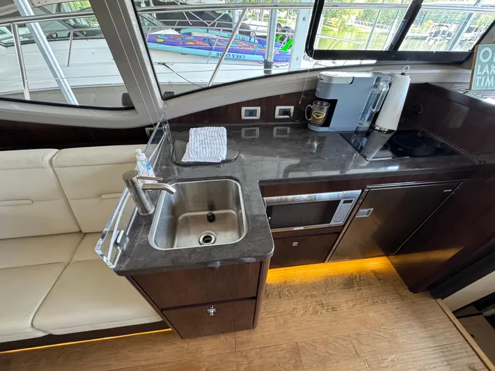 Finale Yacht Photos Pics 2017 Sea Ray Sundancer 400 yacht interior kitchen with sink, appliances, and seating.