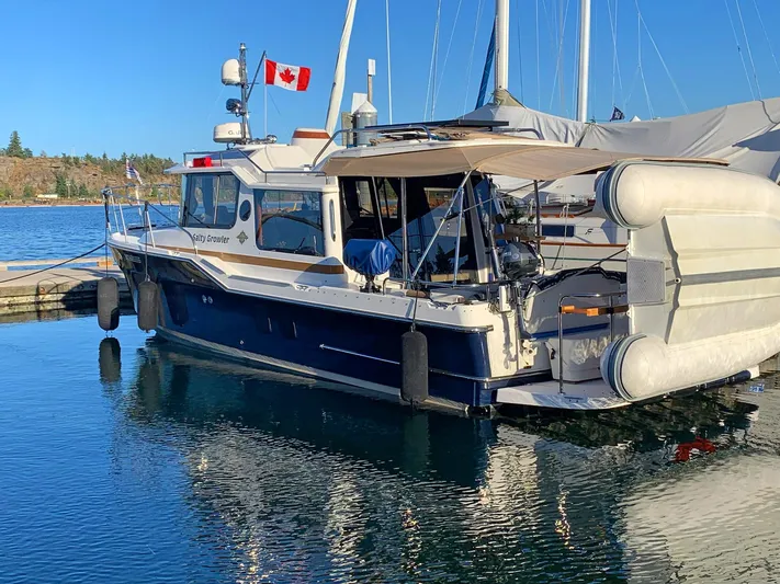 Salty Growler Yacht Photos Pics 2017 Ranger Tugs R-29 S boat docked, Canadian flag, calm water, clear sky.
