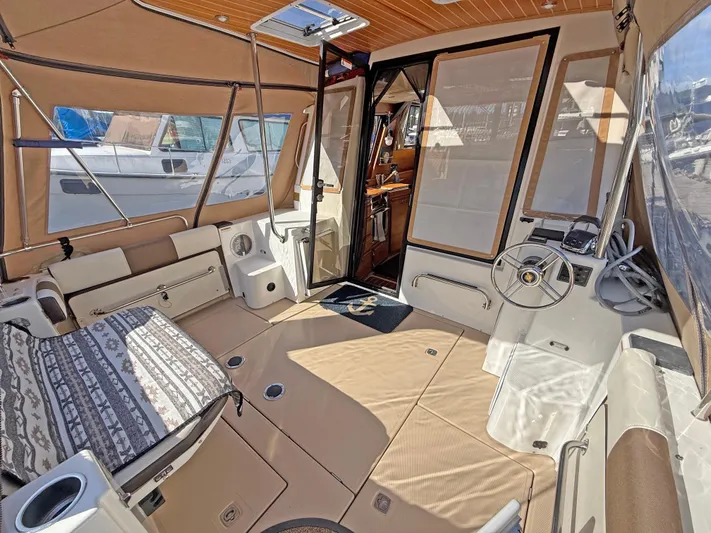 Salty Growler Yacht Photos Pics 2017 Ranger Tugs R-29 S interior with seating, steering wheel, and panoramic windows.