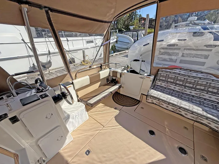 Salty Growler Yacht Photos Pics 2017 Ranger Tugs R-29 S interior with seating, helm, and canopy in a marina setting.