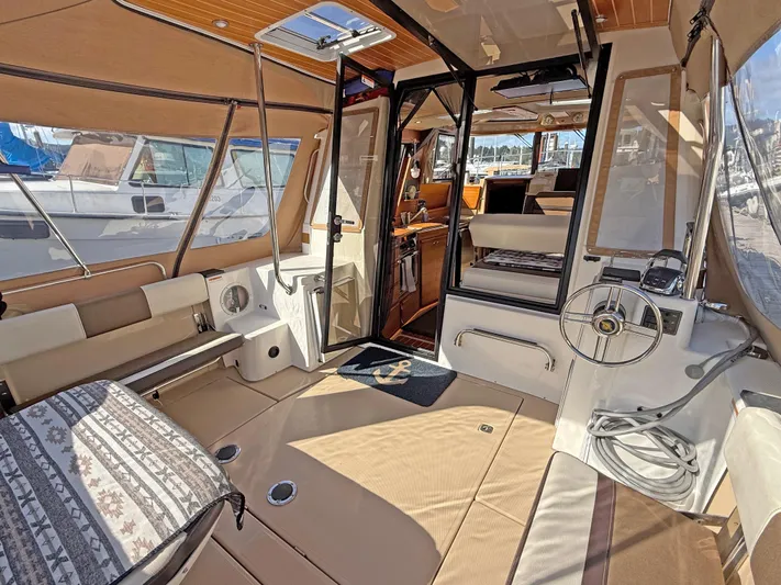 Salty Growler Yacht Photos Pics 2017 Ranger Tugs R-29 S interior with seating, steering wheel, and open cabin view.