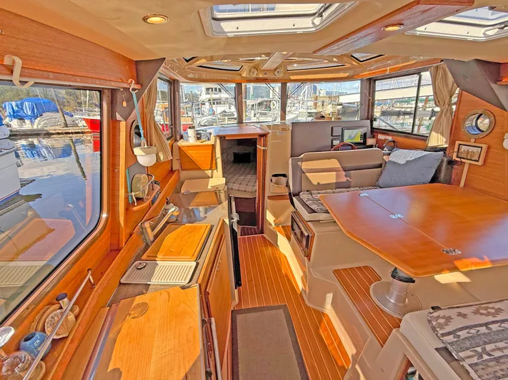 Salty Growler Yacht Photos Pics 2017 Ranger Tugs R-29 S interior with wood finishes, spacious seating, and large windows.