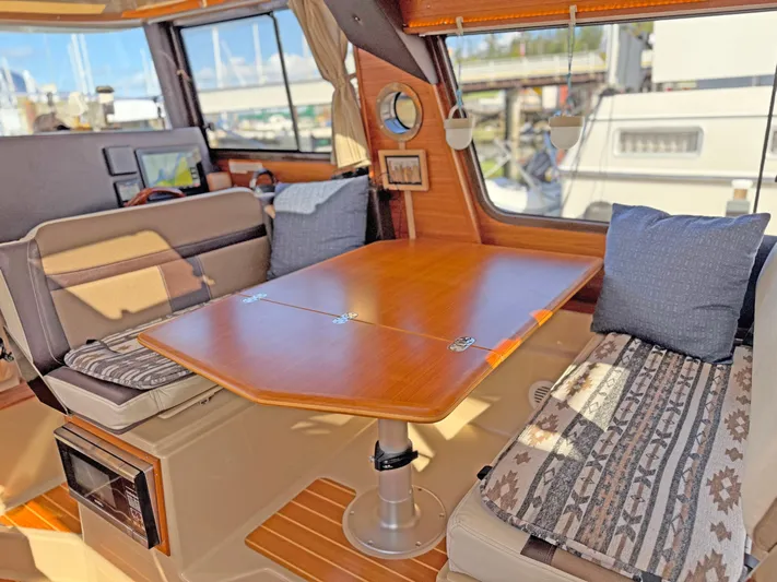 Salty Growler Yacht Photos Pics Interior of 2017 Ranger Tugs R-29 S with wooden table and cushioned seating.