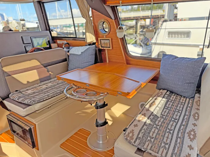 Salty Growler Yacht Photos Pics Interior of 2017 Ranger Tugs R-29 S with cozy seating and wooden table.