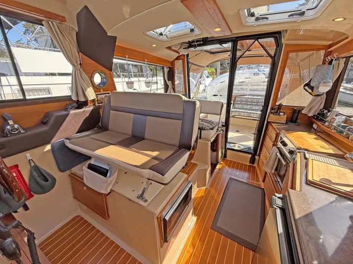 Salty Growler Yacht Photos Pics 2017 Ranger Tugs R-29 S interior with wood flooring, seating, and kitchen area.