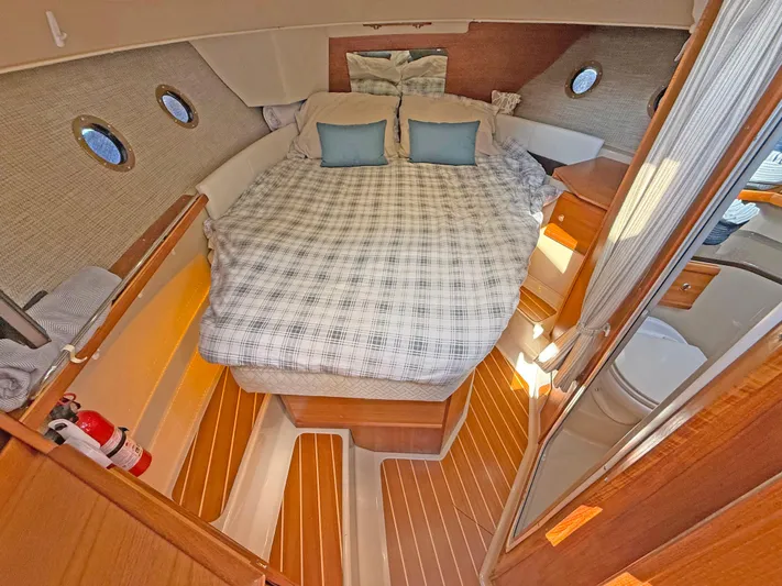 Salty Growler Yacht Photos Pics Cozy cabin interior of 2017 Ranger Tugs R-29 S with bed and wooden flooring.