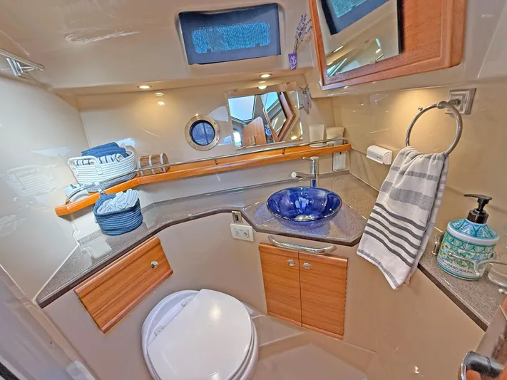 Salty Growler Yacht Photos Pics 2017 Ranger Tugs R-29 S bathroom with modern fixtures, blue sink, and wooden cabinetry.