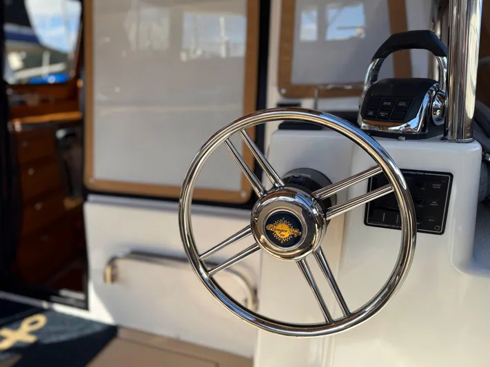 Salty Growler Yacht Photos Pics Steering wheel of 2017 Ranger Tugs R-29 S boat, showcasing sleek design and controls.