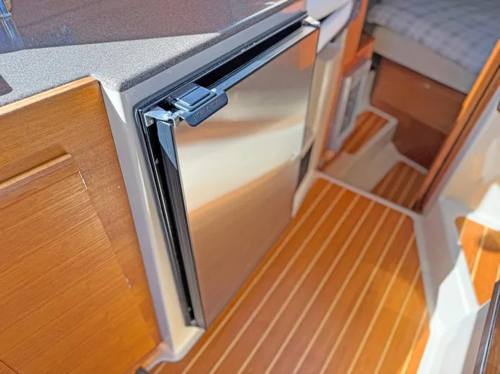 Salty Growler Yacht Photos Pics 2017 Ranger Tugs R-29 S interior with wood flooring and compact stainless steel fridge.