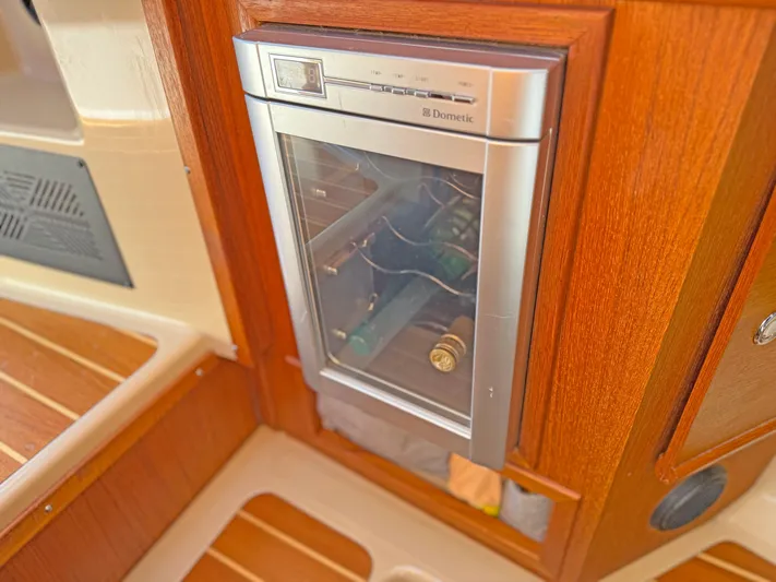 Salty Growler Yacht Photos Pics 2017 Ranger Tugs R-29 S interior with built-in Dometic fridge, wood paneling, and flooring.