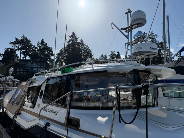 Salty Growler Yacht Photos Pics 2017 Ranger Tugs R-29 S docked under a bright sun, surrounded by trees and other boats.