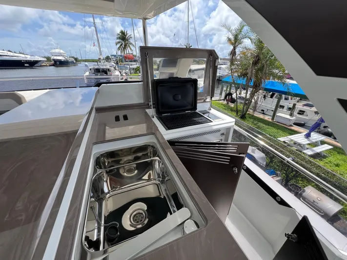  Yacht Photos Pics Outdoor kitchen on 2020 Galeon 680 Fly yacht with sink and grill, docked at marina.