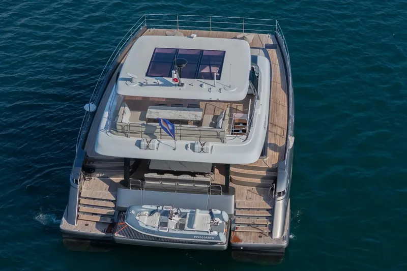  Yacht Photos Pics 2023 Sunreef 60 Power yacht on water, aerial view, featuring spacious deck and tender.