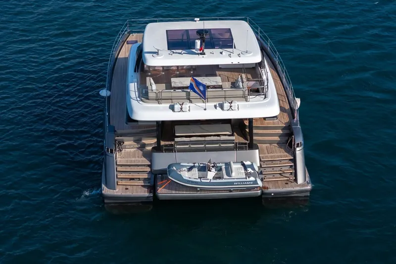  Yacht Photos Pics 2023 Sunreef 60 Power yacht on water, rear view with tender boat.