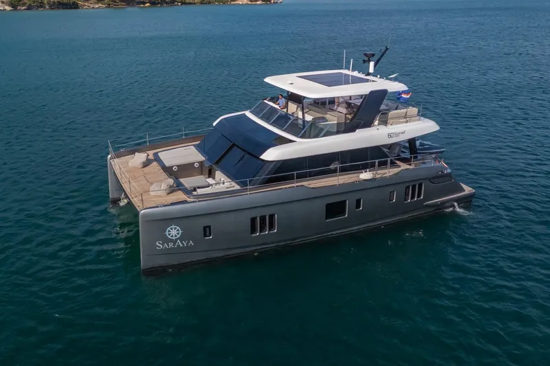  Yacht Photos Pics 2023 Sunreef 60 Power yacht cruising on calm blue waters.