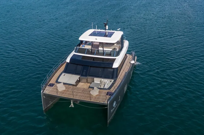  Yacht Photos Pics 2023 Sunreef 60 Power yacht cruising on open water, aerial view.