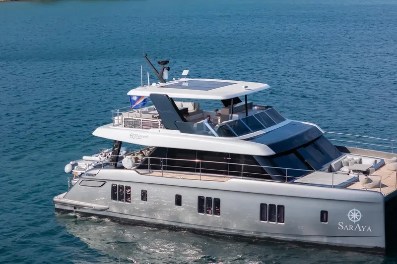  Yacht Photos Pics 2023 Sunreef 60 Power yacht cruising on blue ocean waters.