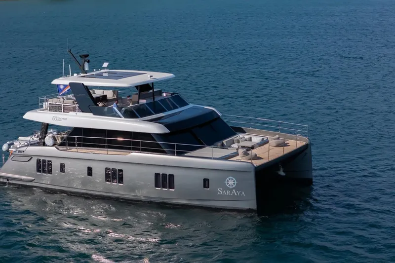  Yacht Photos Pics 2023 Sunreef 60 Power yacht cruising on open water, featuring sleek design and spacious deck.