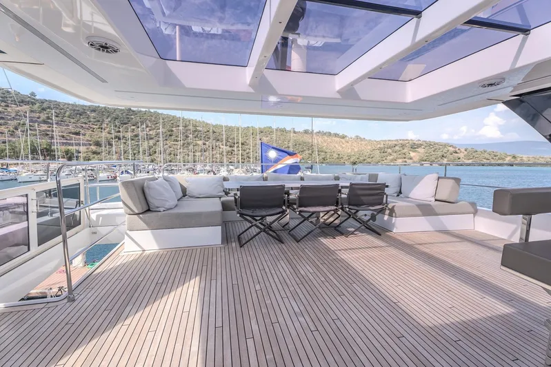  Yacht Photos Pics Luxurious Sunreef 60 Power yacht deck with seating, 2023 model, overlooking serene marina.