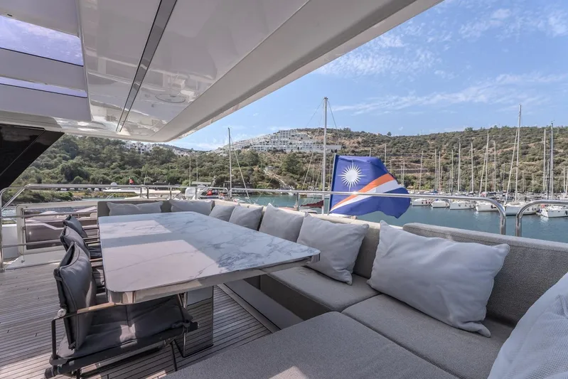  Yacht Photos Pics Luxurious Sunreef 60 Power yacht deck with elegant seating, overlooking marina and scenic hills.