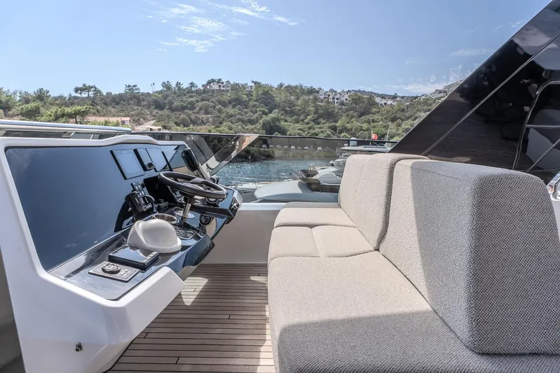  Yacht Photos Pics Luxurious Sunreef 60 Power yacht helm with plush seating, 2023 model, docked by scenic shoreline.