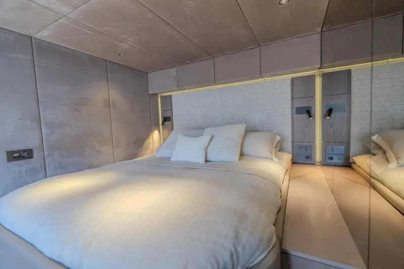  Yacht Photos Pics Luxurious bedroom interior on 2023 Sunreef 60 Power yacht, featuring elegant bedding and modern lighting.