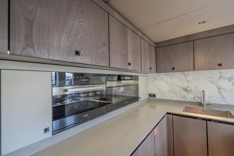  Yacht Photos Pics Modern kitchen interior on 2023 Sunreef 60 Power yacht with sleek cabinetry and marble backsplash.
