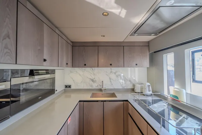  Yacht Photos Pics Modern kitchen interior on 2023 Sunreef 60 Power yacht with sleek cabinetry and marble backsplash.