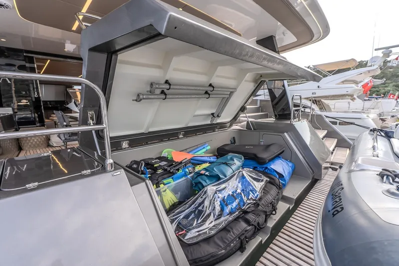  Yacht Photos Pics 2023 Sunreef 60 Power yacht with open storage compartment filled with water sports gear.