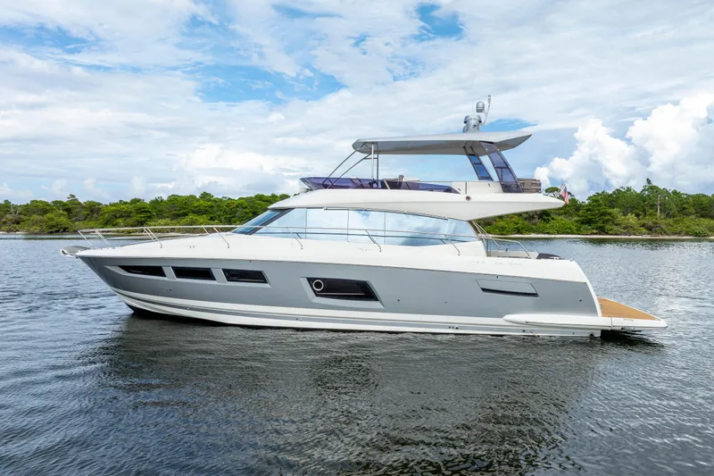 Our Trade Yacht Photos Pics 2017 Prestige 560 yacht cruising on a serene lake with lush greenery.