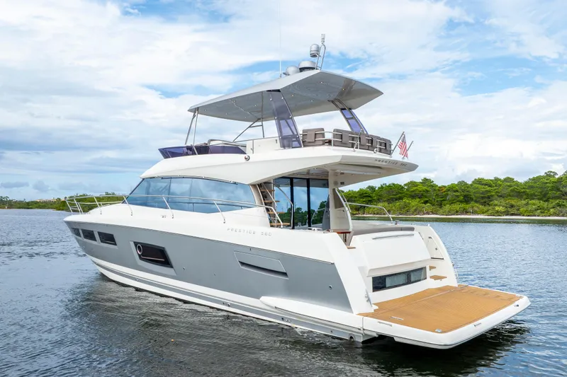 Our Trade Yacht Photos Pics Luxury 2017 Prestige 560 yacht cruising on calm waters under a partly cloudy sky.