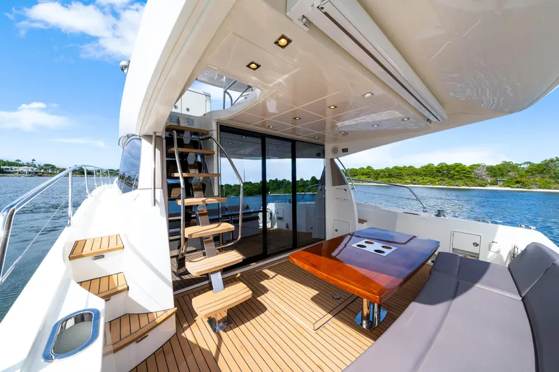 Our Trade Yacht Photos Pics Luxurious 2017 Prestige 560 yacht deck with seating, table, and scenic water view.