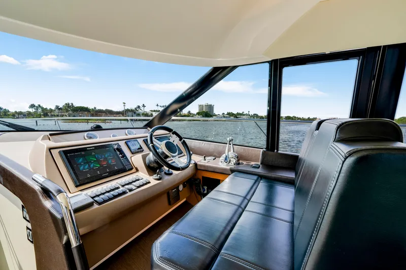 Our Trade Yacht Photos Pics Interior view of 2017 Prestige 560 yacht helm with modern controls and waterfront scenery.