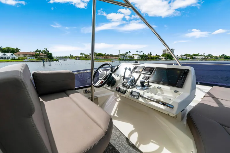 Our Trade Yacht Photos Pics Cockpit of 2017 Prestige 560 yacht with modern controls and waterfront view.