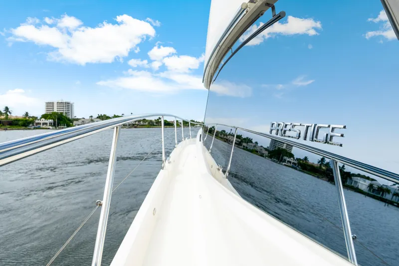 Our Trade Yacht Photos Pics 2017 Prestige 560 yacht cruising on a scenic waterway under a clear blue sky.