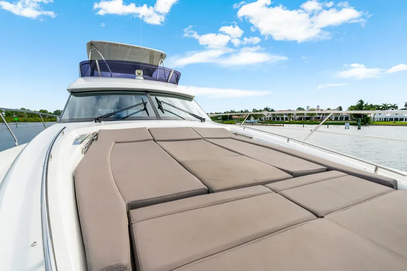 Our Trade Yacht Photos Pics 2017 Prestige 560 yacht with spacious sun deck, cruising on a serene waterway.