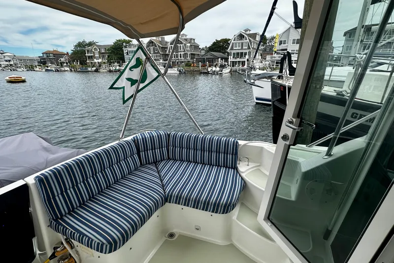 Sull Mates Yacht Photos Pics 2019 Back Cove 37 boat with striped seating, docked in a scenic marina.