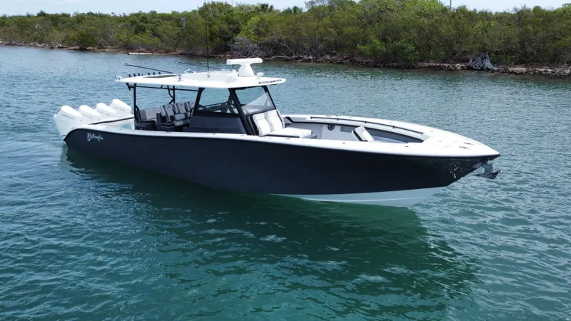  Yacht Photos Pics 2023 Yellowfin 42 boat cruising on a serene waterway with lush greenery in the background.