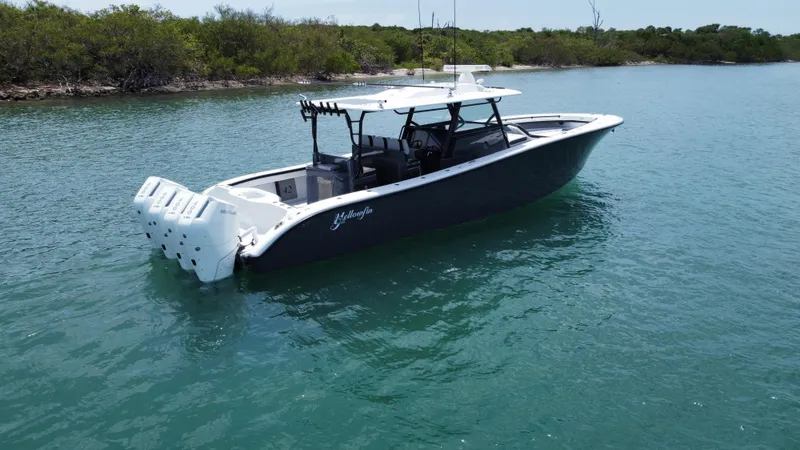  Yacht Photos Pics 2023 Yellowfin 42 boat on calm water, featuring sleek design and powerful engines.