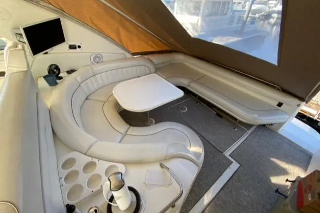 Fresh Water 450 Sundancer Yacht Photos Pics 1997 Sea Ray 450 Sundancer interior with white seating, table, and TV.