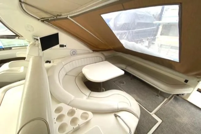 Fresh Water 450 Sundancer Yacht Photos Pics 1997 Sea Ray 450 Sundancer interior with curved seating, table, and mounted TV.