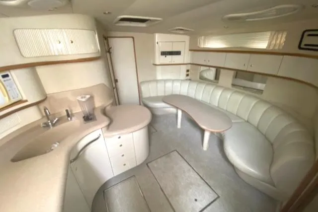 Fresh Water 450 Sundancer Yacht Photos Pics Interior of 1997 Sea Ray 450 Sundancer yacht with curved seating and kitchenette.