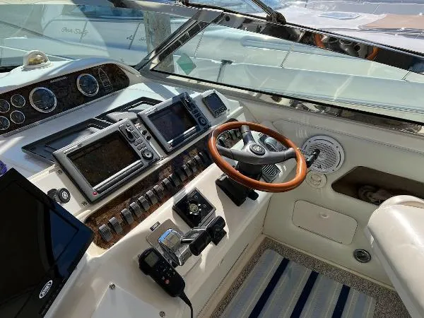 Fresh Water 450 Sundancer Yacht Photos Pics 1997 Sea Ray 450 Sundancer helm with modern navigation equipment and wooden steering wheel.