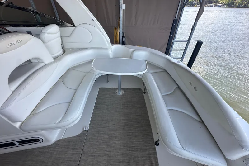  Yacht Photos Pics 2004 Sea Ray 380 Sundancer interior with white seating and table, docked by the water.
