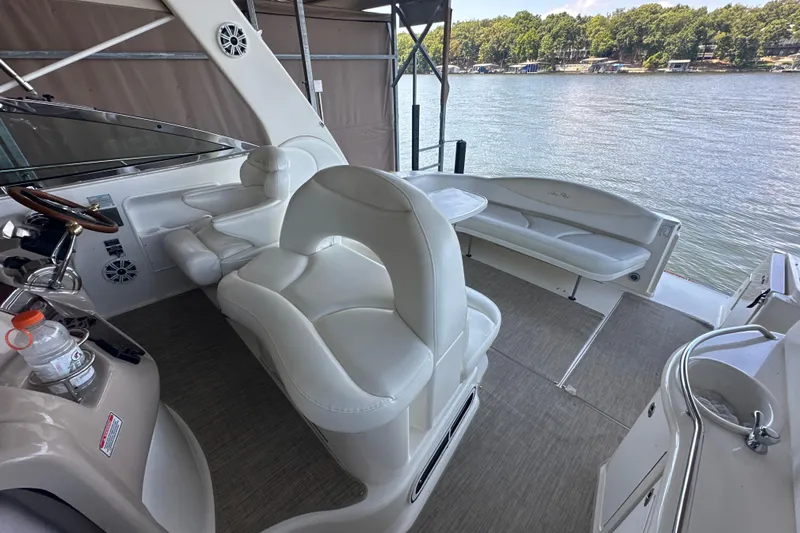  Yacht Photos Pics 2004 Sea Ray 380 Sundancer cockpit with white seating, overlooking a serene lake view.